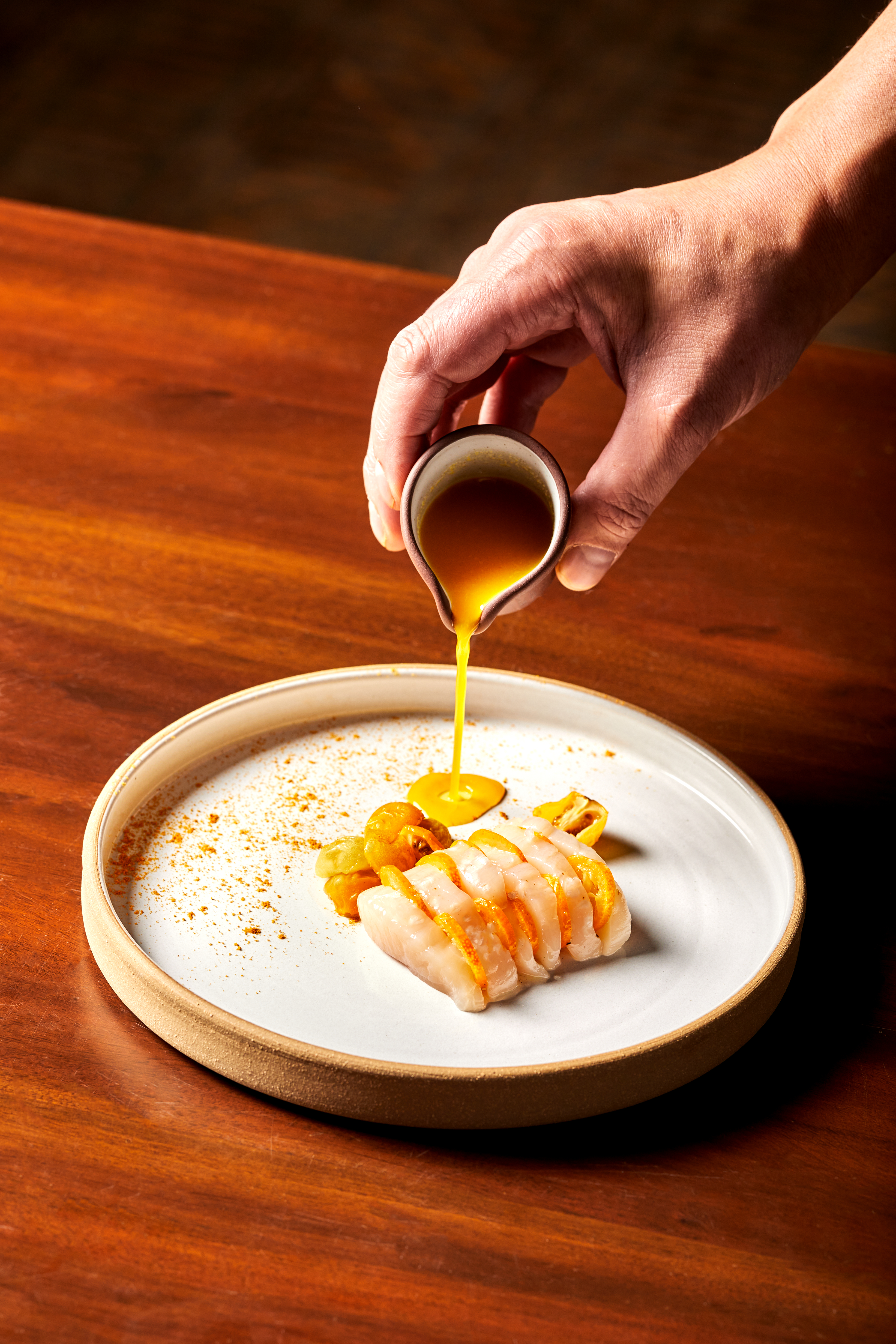 A plate of ceviche with a sauce poured over it. 